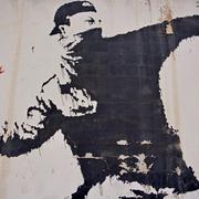 Banksyjevo djelo na zidu koji dijeli Izrael od Palestine - Bacajmo cvijeće, a ne kamenje na druge