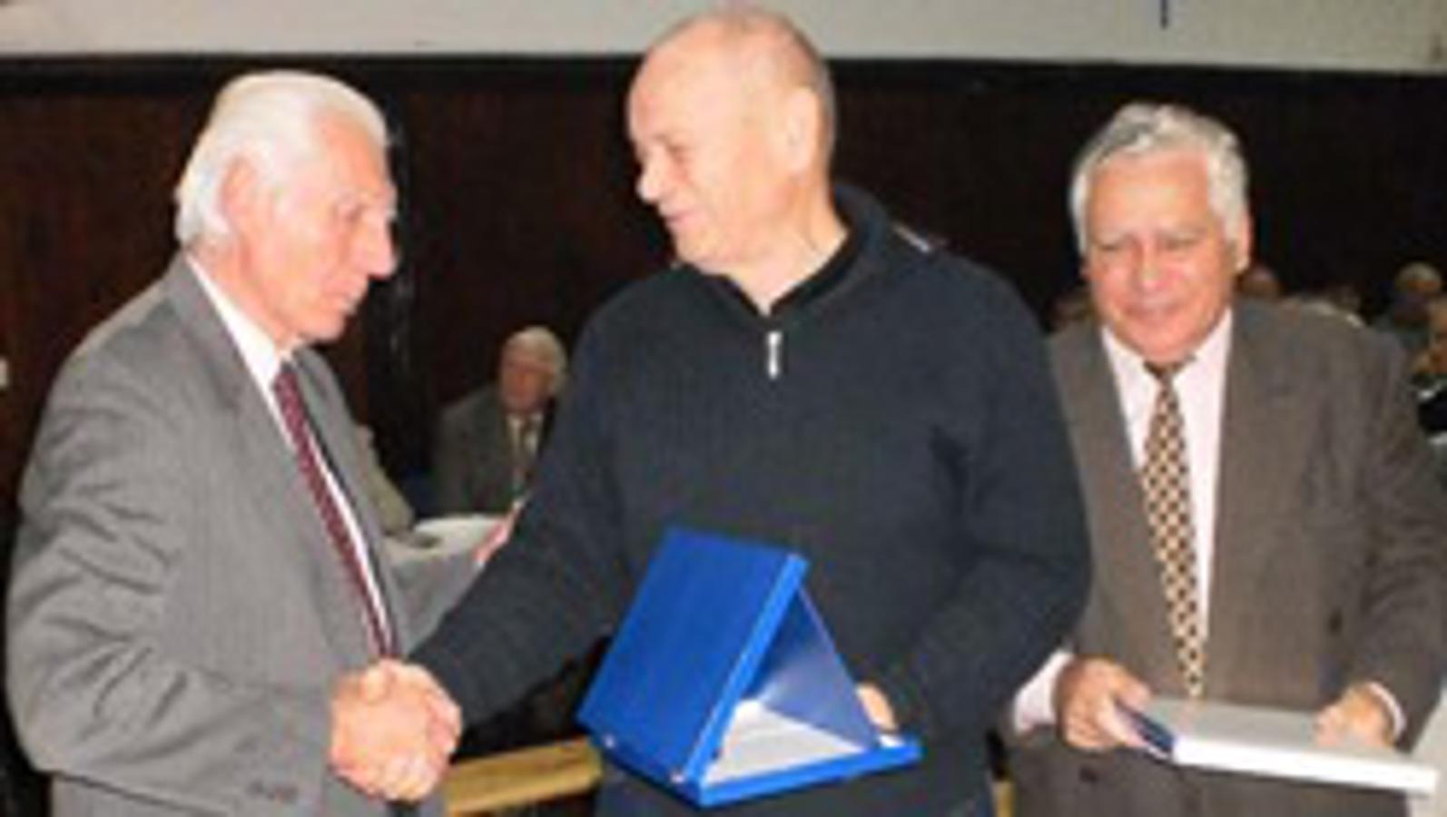 Tomislav Lojen uručuje plaketu Peri Kataliniću, a Željko Čeglaj monografiju.