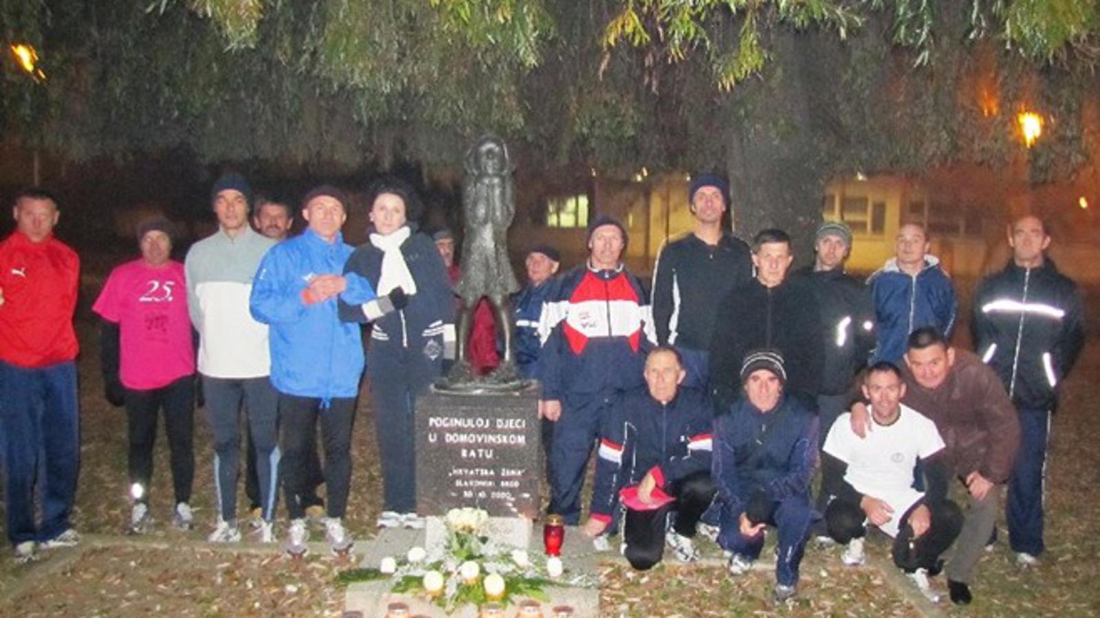 Sudionici noćnog polumaratona u slavu Vukovara kod spomenika Djevojčica